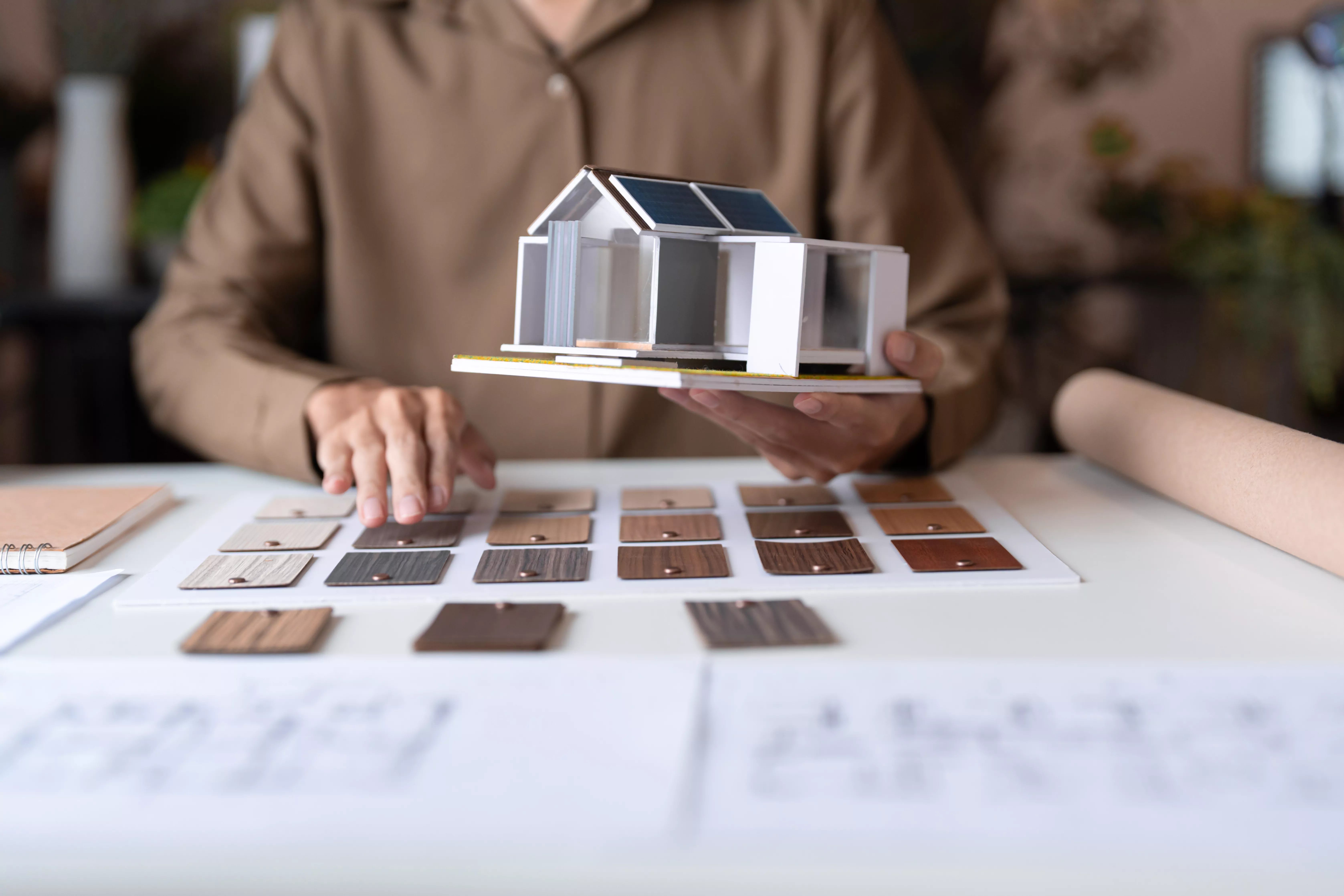Bauplanung mit Architekturmodell, Materialmustern und Grundrissplänen